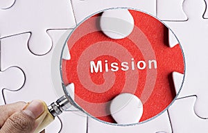 Close up Magnifying glass searching missing puzzle peace Mission