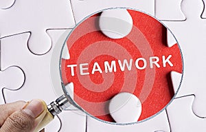 Close up Magnifying glass searching missing puzzle peace Teamwork