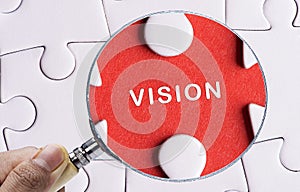 Close up Magnifying glass searching missing puzzle peace Vision