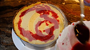 close-up of making a cake. impregnation of sponge cake with red cherry juice.