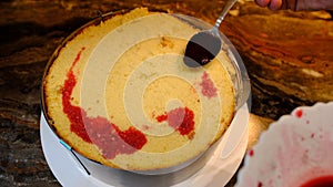 close-up of making a cake. impregnation of sponge cake with red cherry juice.