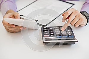 Close up of male accountant or banker making calculations. Savings, finances and economy concept photo