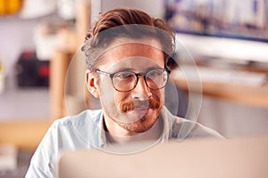 Close Up Of Male Architect In Office Working On Desktop Computer Viewed From Behind Screen