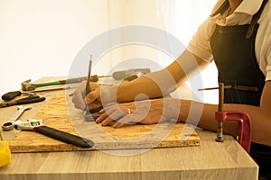 Close-up of male carpenter hands drawing mark on wooden flooring