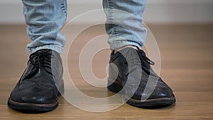 Close-up of male caucasian feet in elegant broggi shoes stomping on the floor. Adult man jumping down, turning and