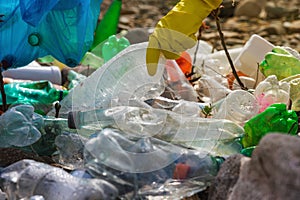 Close up of male collecting plastic garbage on the beach in trash bag. Earth day, Environmental protection concept