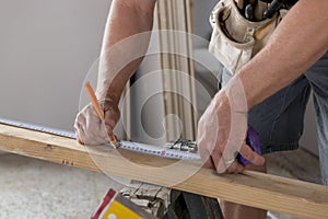 Close up male constructor carpenter or builder hands detail working and measuring wood in industrial construction job concept photo