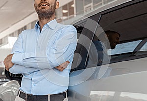 Close up of male consultant in auto show standing near cars