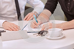 Close up of a male customer signing the contract