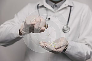 Close-up of male doctor giving too much pills.  Overdose concept