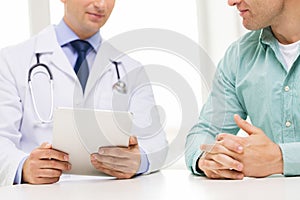 Close up of male doctor and patient with tablet pc