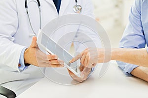 Close up of male doctor and patient with tablet pc