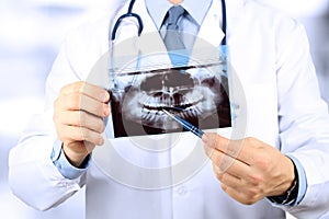 Close-up Of Male Doctor Pointing At Teeth X-ray