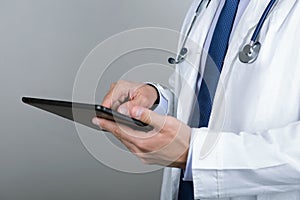 Close-up of male doctor's hands touching digital tablet pc