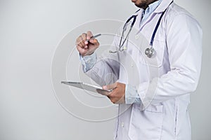 Close-up of male doctor using digital tablet on grey background