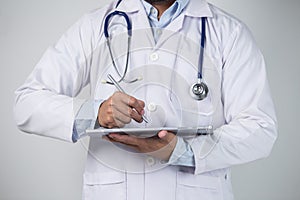 Close-up of a male doctor using digital tablet on grey background