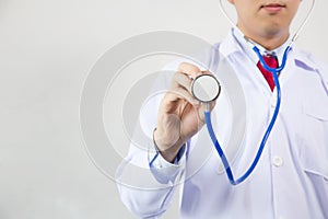 Close-up of male doctor using stethoscope and focusing on stethoscope