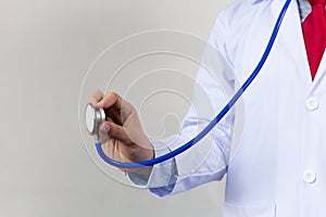 Close-up of male doctor using stethoscope and focusing on stethoscope.