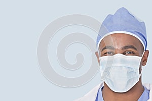Close-up of a male doctor wearing facemask over light blue background photo