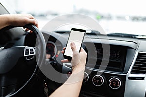 Close-up of male driver hands using mobile phone in luxury car.