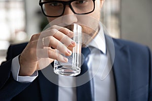 Close up of male employee drink clean mineral water