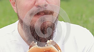 Close-up male face eating a big burger