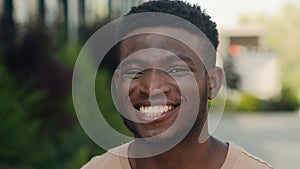 Close up male face happiness expression portrait African American happy smiling guy in city laugh funny reaction enjoy