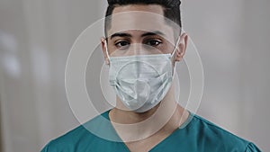 Close up male face hispanic arab man doctor nurse in safety medical mask confident looking at camera adult latin guy