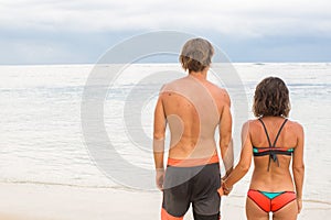 Close up male and female hands holding together on blurred sea a