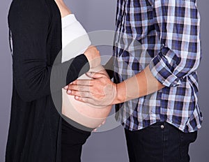 Close up of male and female hands touching pregnant belly