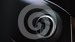 Close up of male finger pressing an engine start stop button in car
