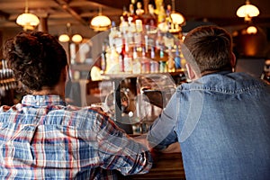 Close up of male friends at bar counter in pub