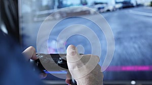 Close up of male gamer hands and joypad. Excited man playing video games on big TV, holding wireless controller and pressing butto