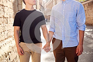 Close Up Of Male Gay Couple On Vacation Holding Hands Walking Along City Street