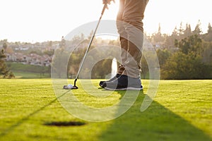 Close Up Of Male Golfer Lining Up Putt On Green