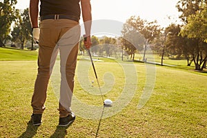 Close Up Of Male Golfer Lining Up Tee Shot On Golf Course