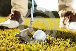 Close-up of male golfer teeing off