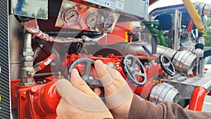 Close up of male hand on control valve in fire engine