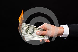 Close up of male hand holding burning dollar money