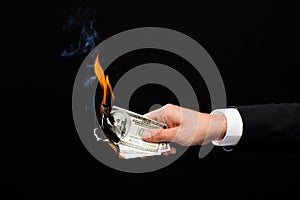 Close up of male hand holding burning dollar money