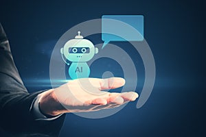 Close up of male hand holding creative AI robot hologram with speech bubble for your text on blue background. Chat GPT and