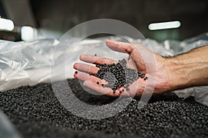 Close up of male hand holding plastic polymer granules