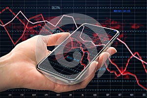Close up of male hand holding smartphone with glowing downward red forex chart on blurry background with index grid. Crisis,
