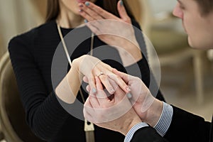 Close Up Of Male Hand Inserting An Engagement Ring Into A Finger.