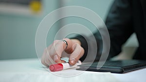 Close-up male hand placing marker at notebook tapping fingers on table. Thoughtful unrecognizable Caucasian troubled man