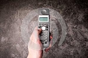 Male hand press on button of an obsolete cellphone