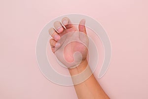 Close up of male hand reaching out ready to help or receive isolated on pink background. Helping hand outstretched for salvation