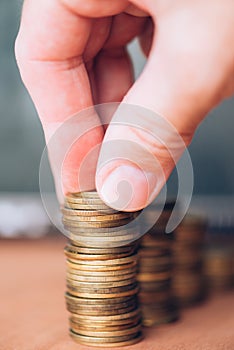 Close up of male hand stacking coins