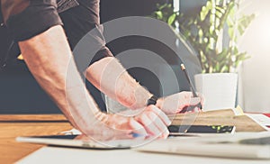 Close-up of male hand on table. Businessman standing near table, leaning his hands on table.