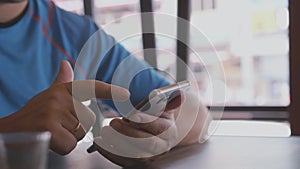 Close up of male hand texting on his phone in a street cafe. 3840x2160